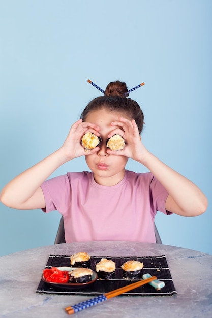 The girl holding the buns has a face like binoculars Home delivery of Japanese cuisine On a blue background in a pink dress Long curly hair It's ridiculous and stupid