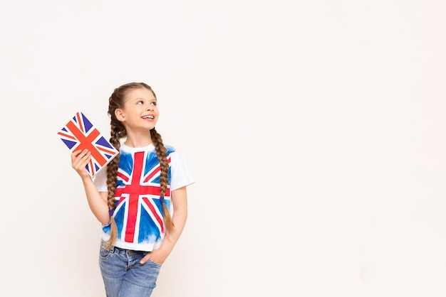 A girl holding an English book points to your advertisement on an isolated background Teaching children English