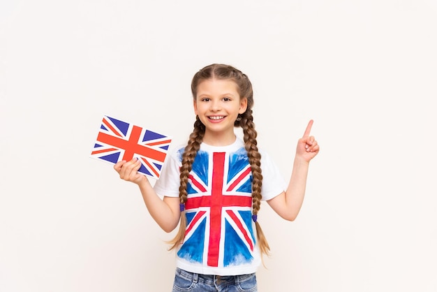 A girl holding an English book points to your advertisement on an isolated background Teaching children English