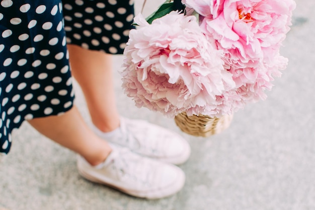 Girl holding flowers legs close up