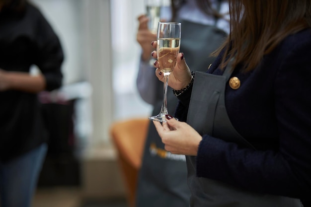 girl holding a glass of champagne in her hands at a party closeup