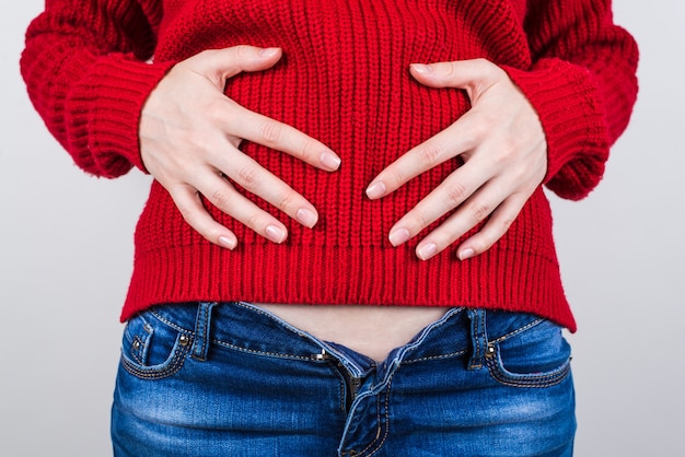 Girl holding hands on tummy after eating too much