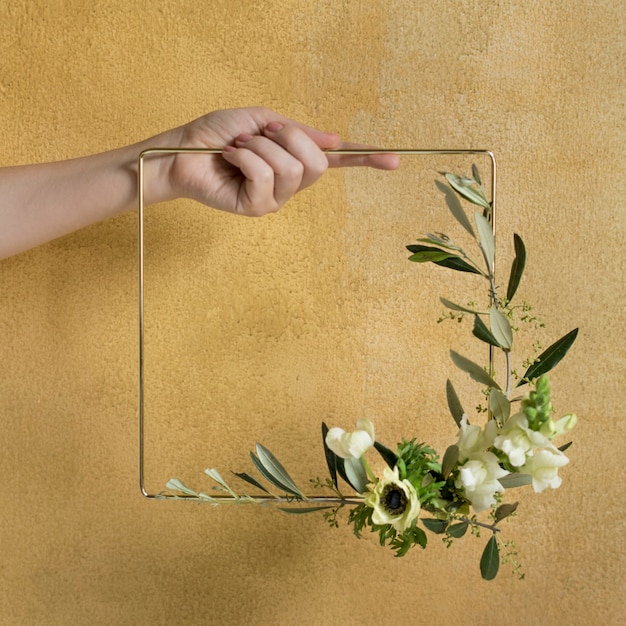 Girl holding a leaf decorated square golden frame