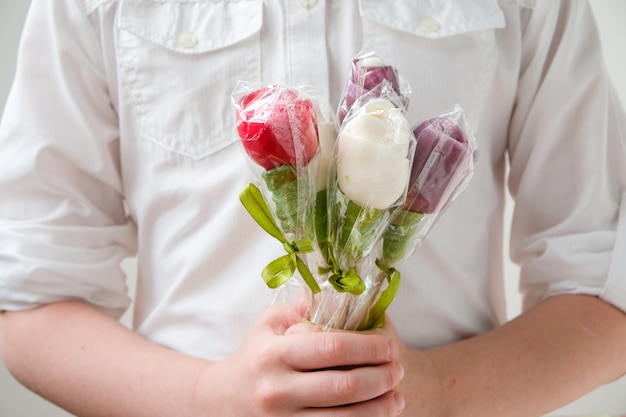 Girl holding lollipops in the shape of flowers