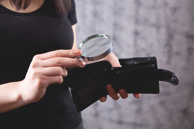 Girl holding a magnifying glass and wallet