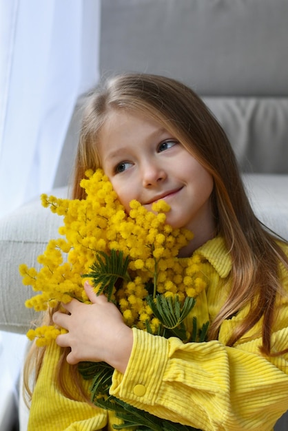 Girl holding mimosa on a white background