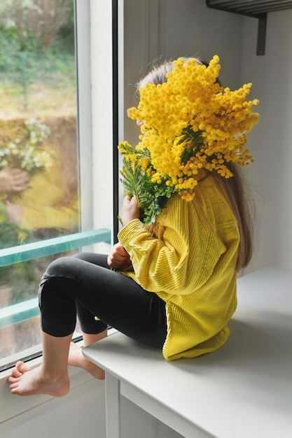 Girl holding mimosa on a white background