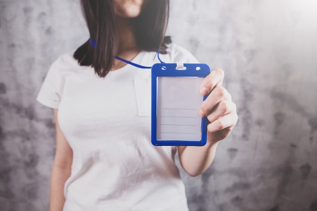 Girl holding name badge in hand, badge mockup