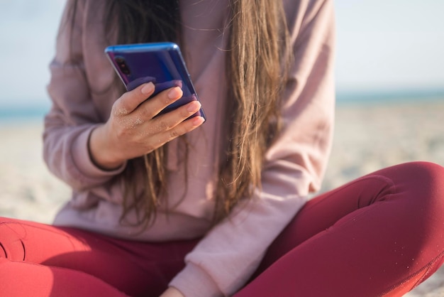 girl holding phone smartphone in hands on the seashore