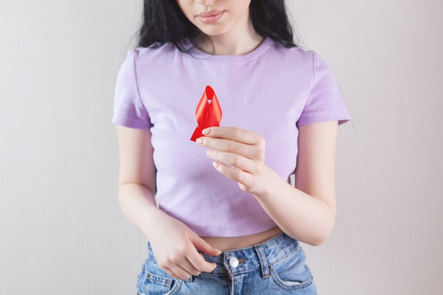 Girl holding red ribbon sign cancer