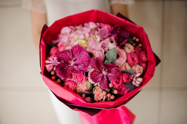 Girl holding a spring bouquet of tender pink and crimson flowers