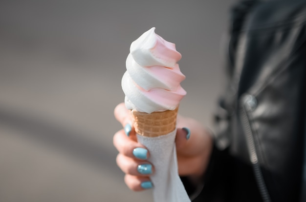 girl holding a waffle cone with ice cream in the park