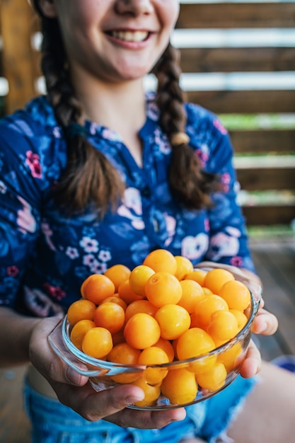 Girl holding yellow plums grown in her garden