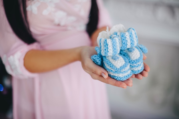 Girl holds baby blue booties in the rivers