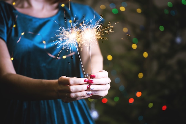 Photo girl holds bengal lights - happy christmas and merry holidays