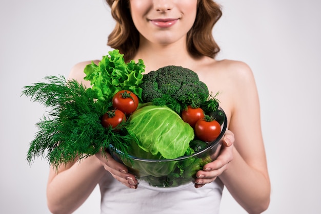 Girl holds fresh vegetables in hands