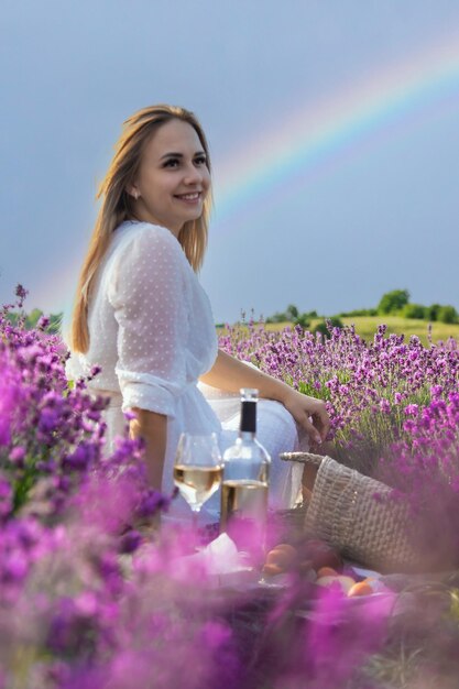 The girl holds a glass of wine on the background of a lavender field Selective focus