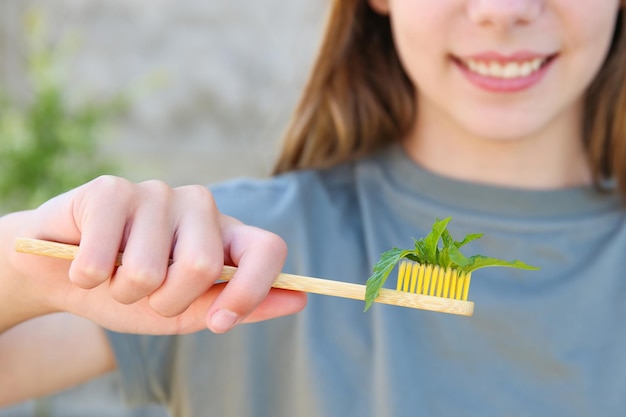 The girl holds a toothbrush with mint in her hand Selective focus on the mint toothbrush