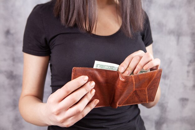 Girl holds wallet in her hands and takes money