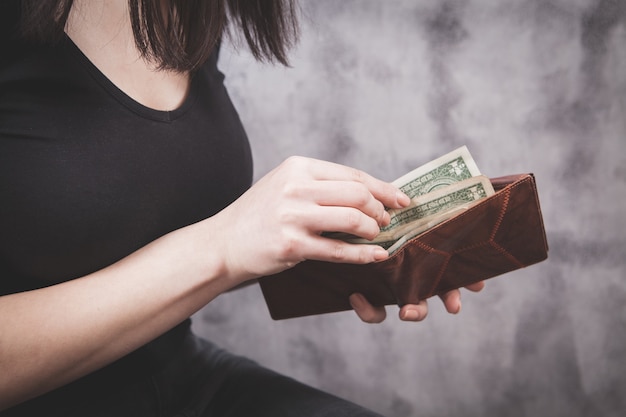 Girl holds wallet in her hands and takes money