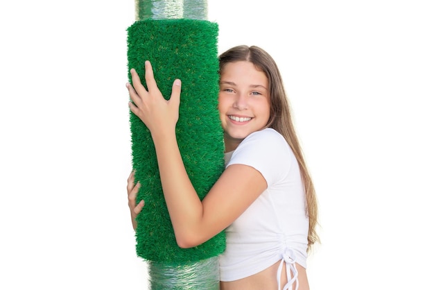 Girl hugging a roll of artificial grass on white background Soft touch of an artificial turf sheet