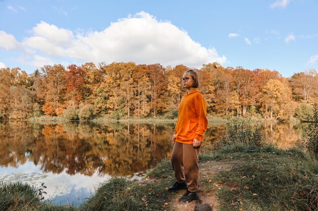 Girl is in the autumn park Autumn atmosphere scenic view of the river