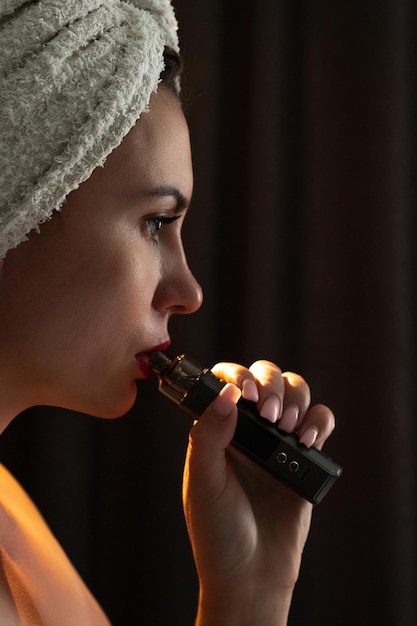 A girl is blowing smoke from a vape a portrait of a girl with red lips who smokes