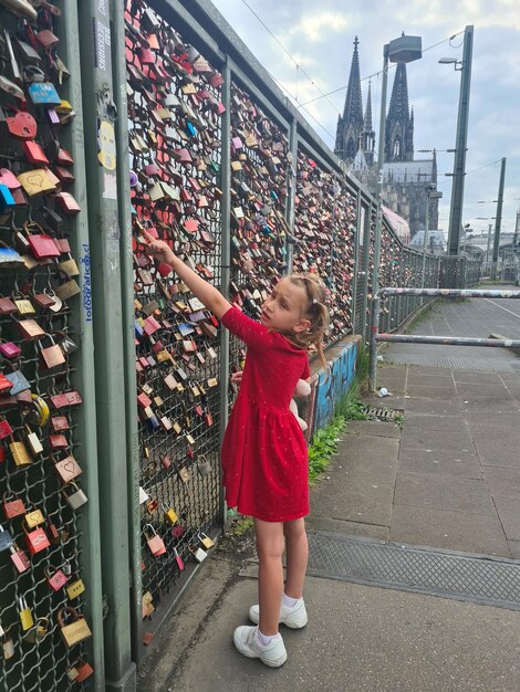 A girl is climbing a bridge with locks that say love locks.