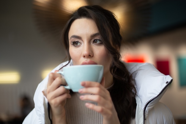 girl is drinking a hot drink in a cafe