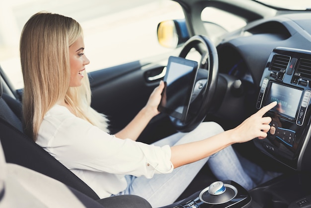 The girl is glad that she is driving this car.