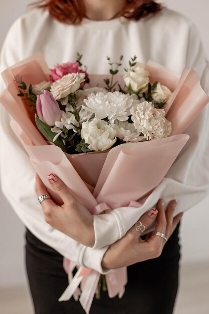 The girl is holding a delicate bouquet of flowers Chrysanthemum rose tulip spray rose