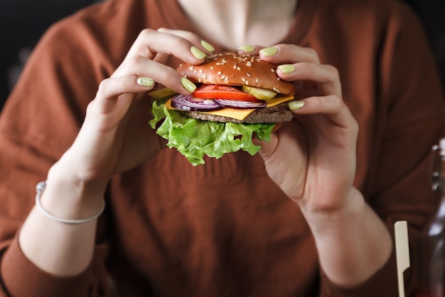 The girl is holding a delicious Burger