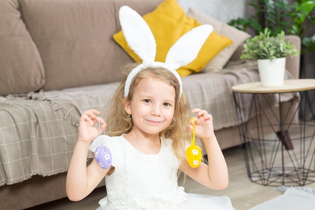 a girl is holding easter eggs and smiling