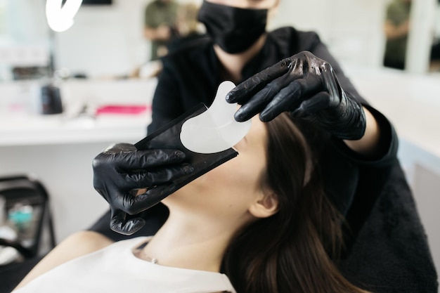 The girl is holding makeup tools Professional makeup artist with a belt bag with tassels makeup brushes Professional Makeup artist doing glamour model makeup at work