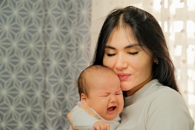 The girl is holding a newborn baby newborn baby crying