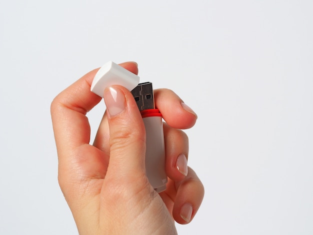 girl is holding an open white usb flash drive