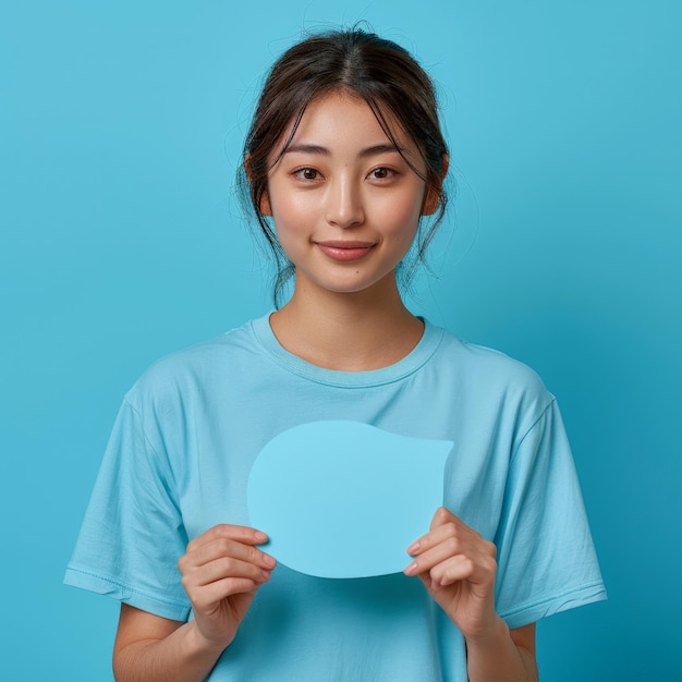 Photo a girl is holding a piece of paper with a blue background