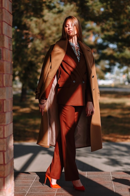 The girl is a model showing fashionable outerwear on the street on the veranda of a summer cafe Clothes for the showroom