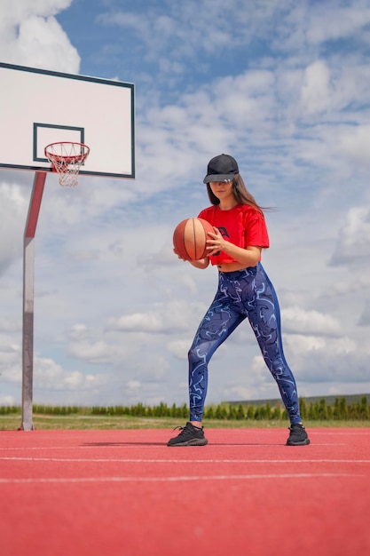 Girl is playing basketball on an outdoor playground