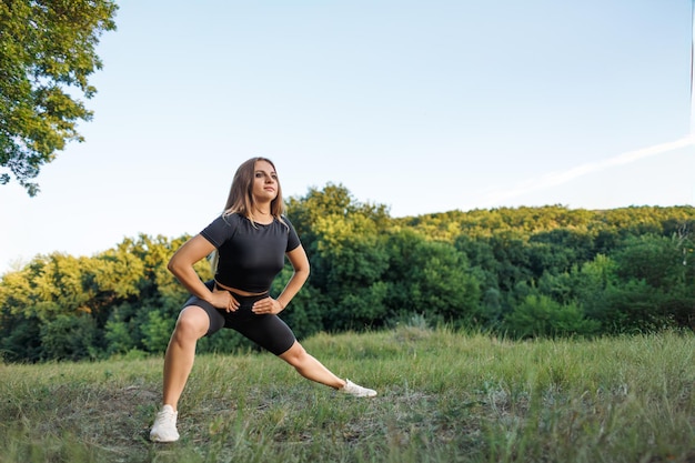 The girl is playing sports outdoors Athletic girl in a tight uniform working outdoors in the park