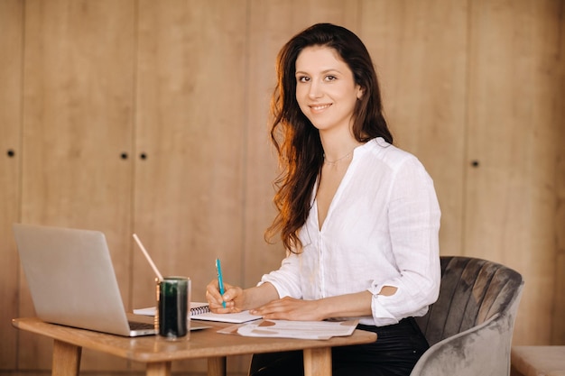 The girl is sitting at a desk in the office and working