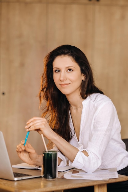 The girl is sitting at a desk in the office and working