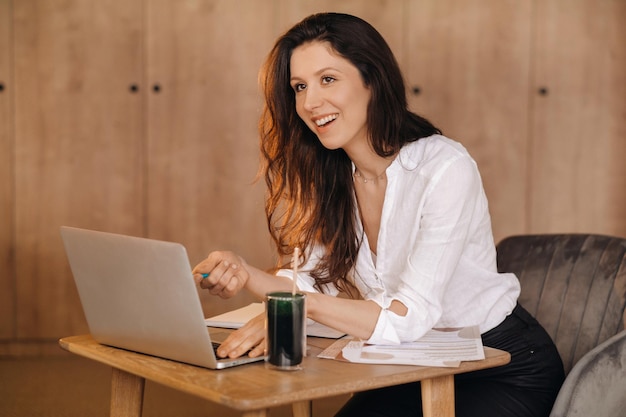 The girl is sitting at a desk in the office and working