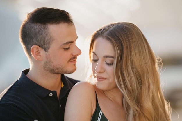 A girl is sitting between the legs of her boyfriend in the evening in Spain