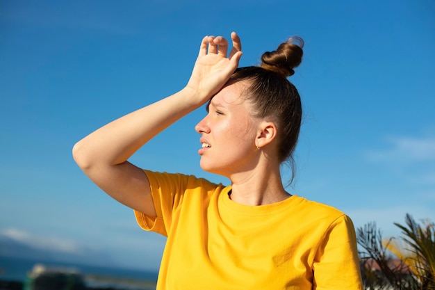 Girl is suffering from heat woman with heatstroke Having sunstroke at summer hot weather Dangerous sun girl under sunshine Headache Person holds hand on head Feeling bad unwell unhealthy