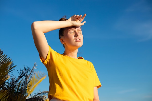 Girl is suffering from heat woman with heatstroke having sunstroke at summer hot weather dangerous