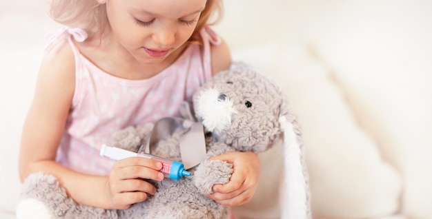 Girl is treating a teddy hare