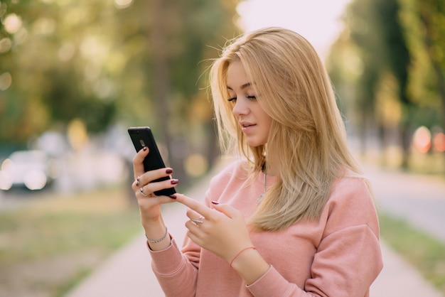 Girl is using smartphone on street