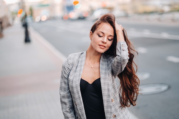 A girl in a jacket and long hair walks through the old city.A beautiful girl smiles.Girl on the road