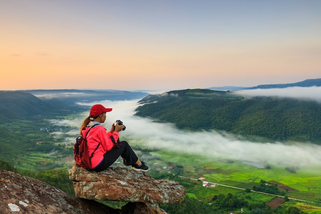 The girl in jacket standing on the mountain